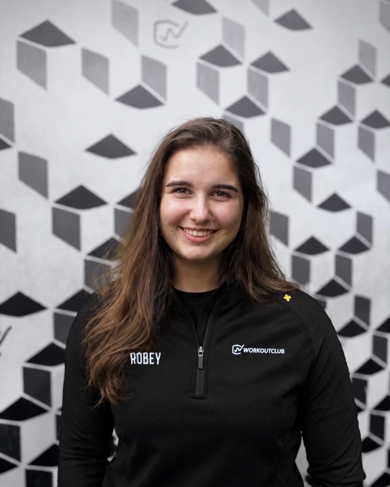 Sanne Heuvelman, lachend, in een zwart Workoutclub-shirt